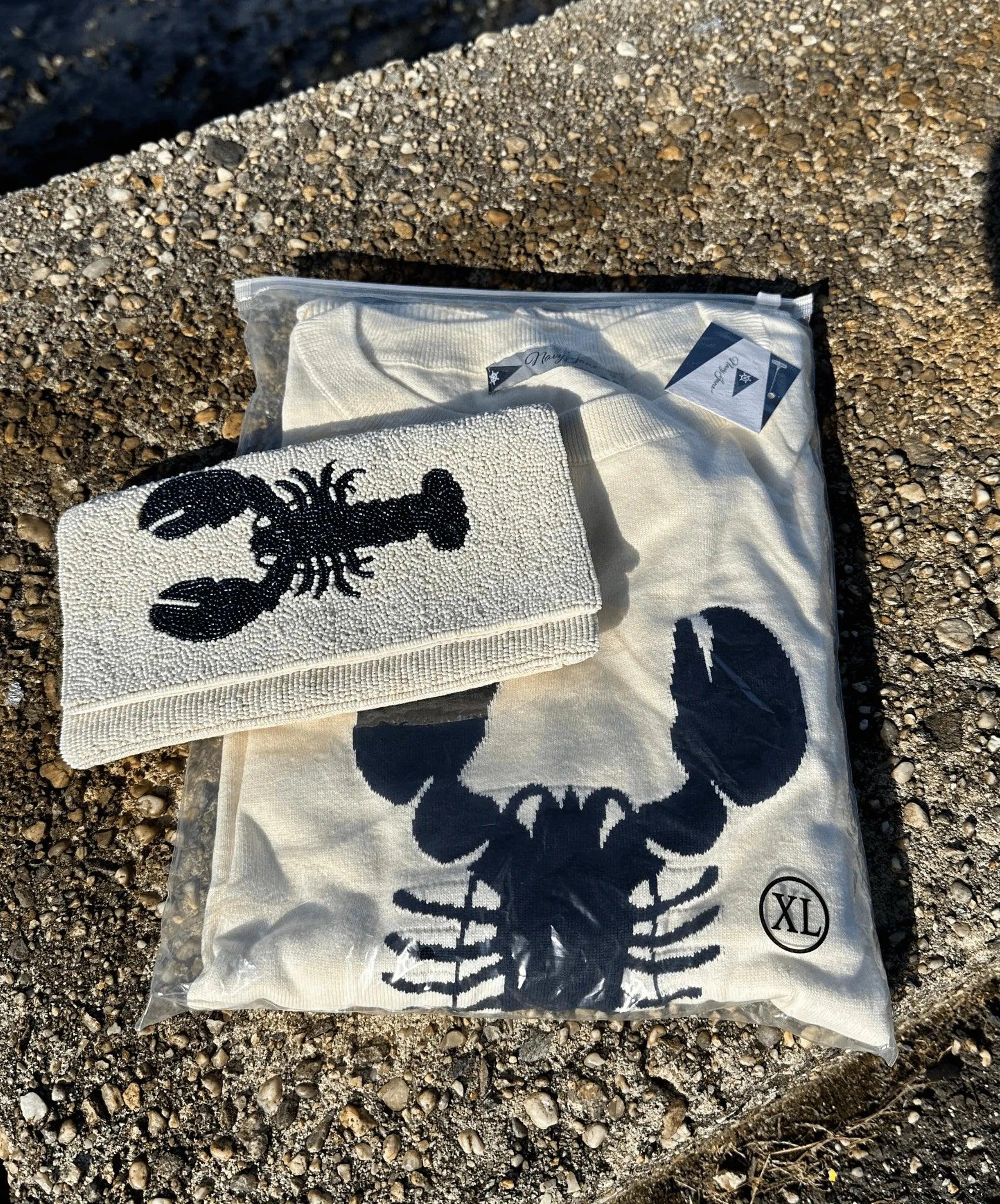 picture of a cream sweater with navy blue lobster design and matching beaded clutch.