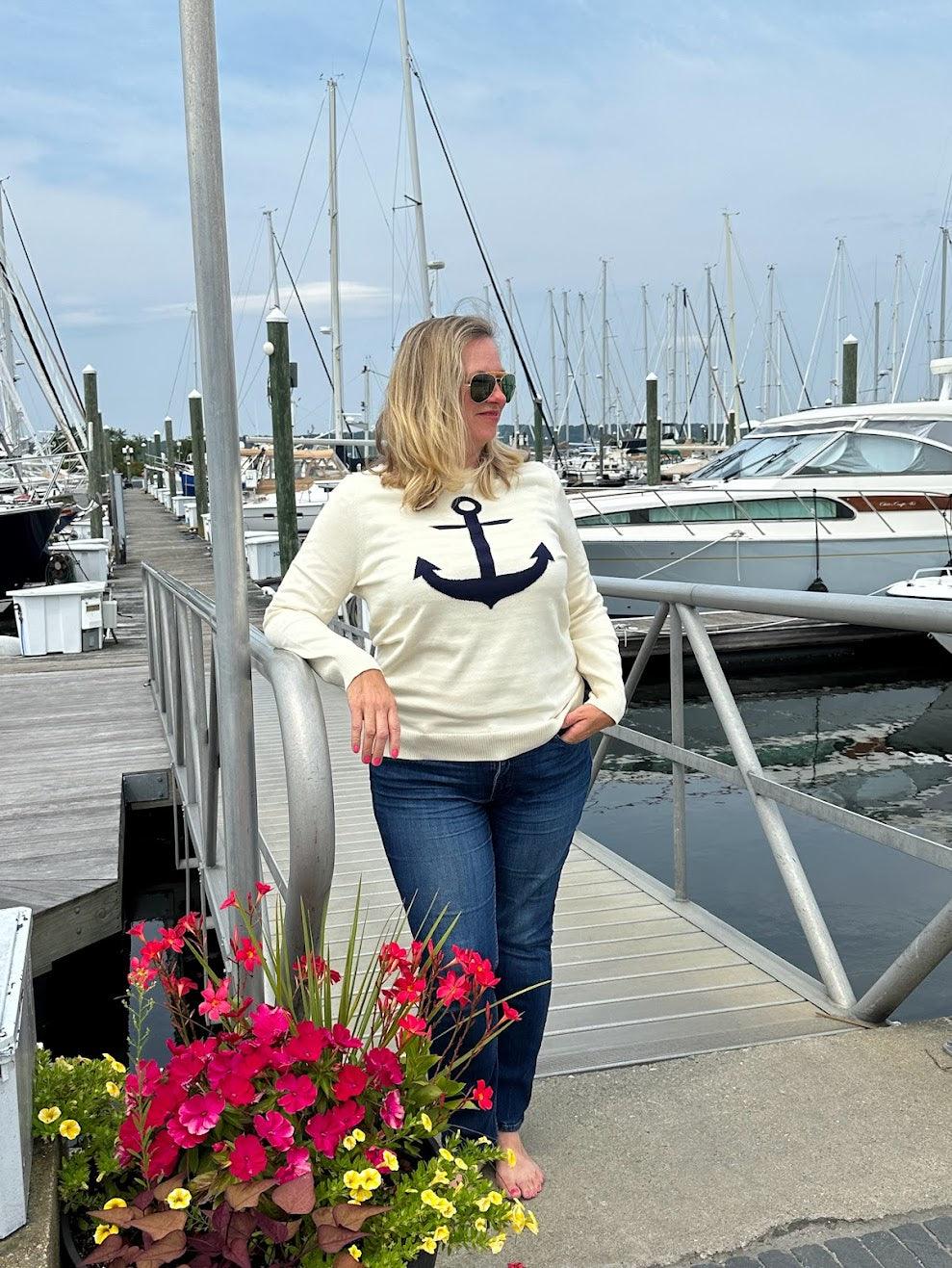 Picture of a woman wearing a cream sweater and navy anchor sweater.  