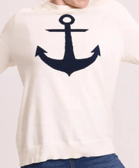 Closeup picture o cream colored sweater with navy anchor