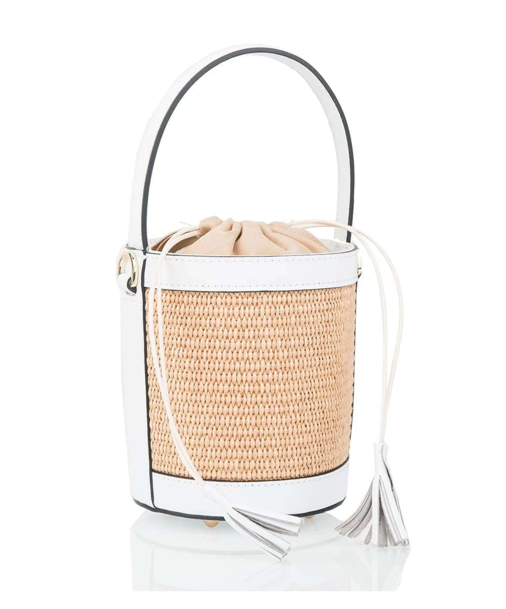 A white  raffia lucket handbag with white leather  detailing and a tassel on the drawstring top.